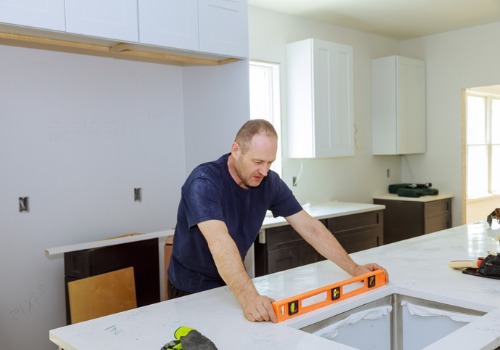 A worker levels a countertop in a kitchen after a homeowner hired Remodeling Contractors in Peoria IL